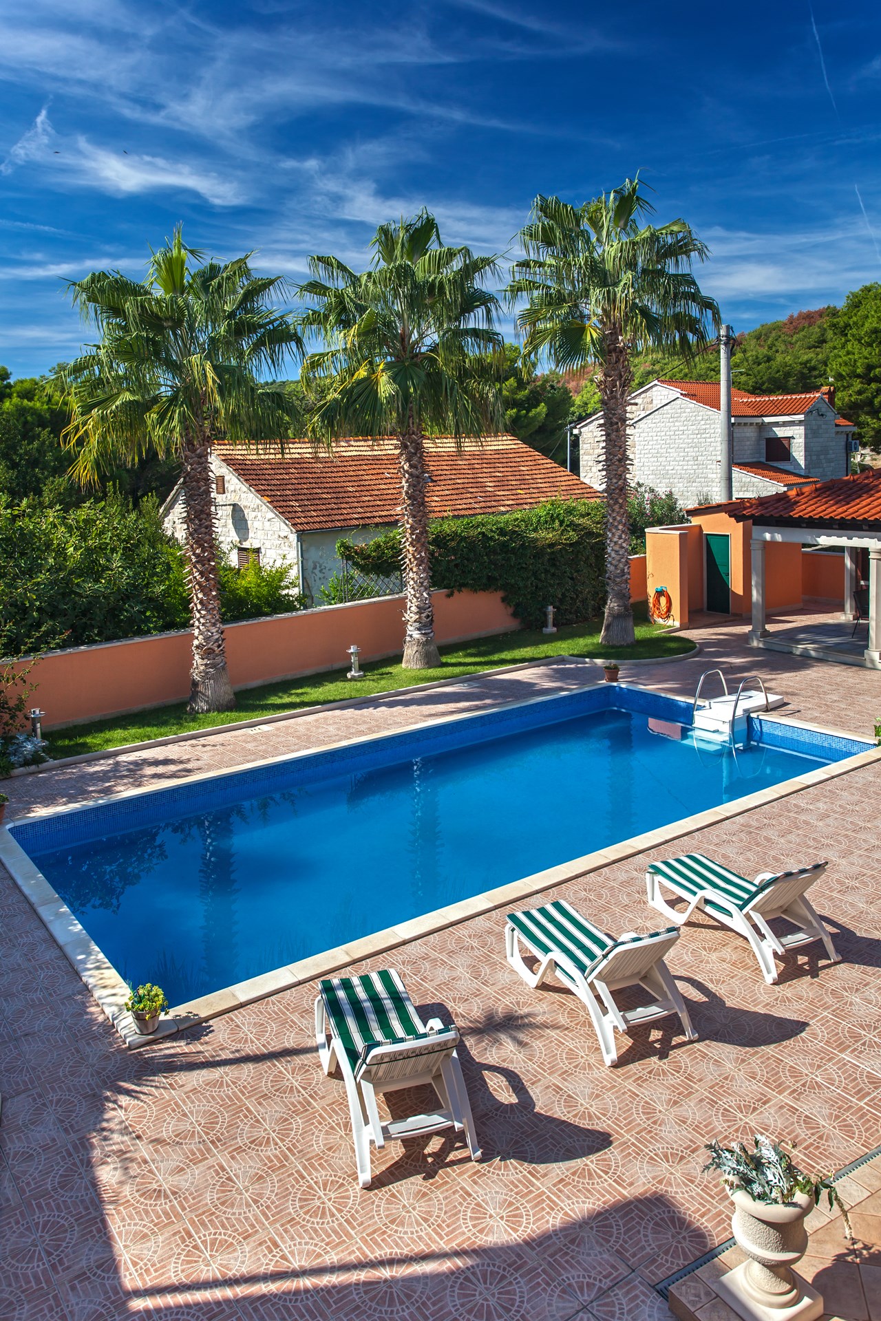 Swimming pool with sunbeds and relaxing area on the front terrace the Villa Rasotica